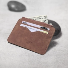 Close-up of brown suede card holder with three slots and a secure zipper coin pocket