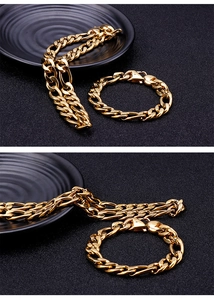 Detailed view of polished gold Cuban link chain necklace and bracelet set on black base