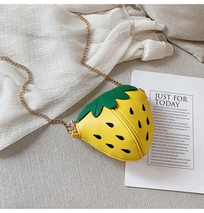 Nahaufnahme der gelben Erdbeertasche mit Blattdetail und goldener Kette