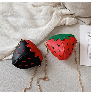 Detail von niedlichen Erdbeer-Mini-Umhängetaschen mit Goldketten in Rot und Schwarz
