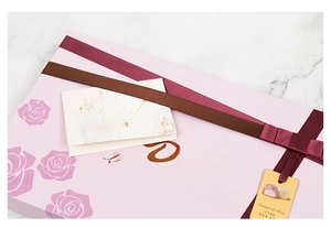 Close-up of elegant pink Dove chocolate gift box with ribbon and greeting card