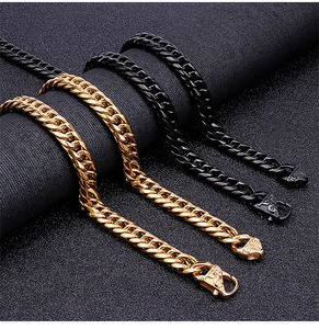 Close-up of gold and black Cuban link chains with ornate engraved lobster clasps
