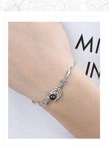 Close-up of heart projection bracelet in silver finish with sparkling zircon inlay on wrist