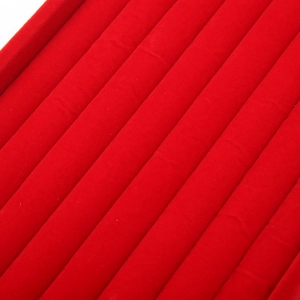 Macro shot of premium red velvet jewelry tray showing soft texture and multiple ring slots
