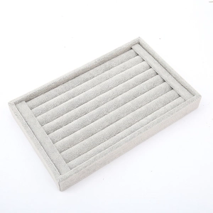Close-up of light grey velvet jewelry tray with seven slots for rings and studs