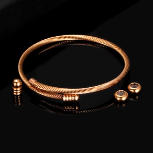 Detailed macro view of a rose gold twisted wire cable bracelet with matching beads