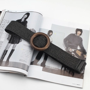 Bohemian black woven elastic belt with a round wooden buckle on a fashion magazine