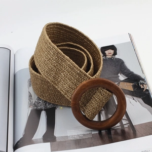 Detail of woven straw belt with brown round wooden buckle on a fashion magazine