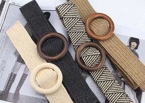 Detailed view of four woven bohemian belts with large round wooden buckles in varied colors