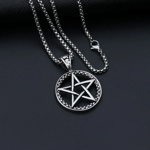 Macro shot of silver metal star pendant necklace with box chain on dark textured surface