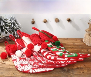 Detail of knitted Christmas stockings with elk and snowflake patterns on wooden surface