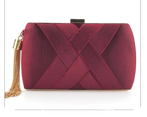 Detail of wine red satin evening clutch with chic gold metal tassels and clasp