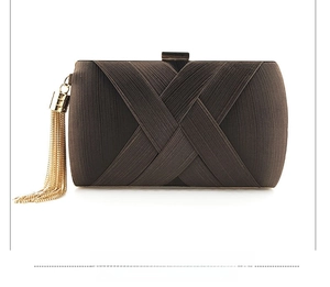 Detail of dark brown satin evening clutch with metallic gold tassels and cross pleat design