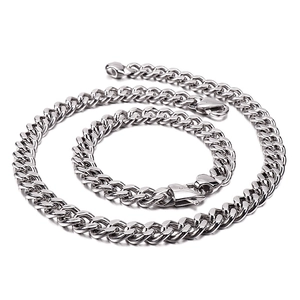 Polished silver stainless steel Cuban link necklace and bracelet set on white background