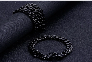 Detail of black stainless steel Cuban chain bracelet with vintage patterned clasp