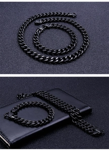 Close-up of black stainless steel Cuban link necklace and bracelet set on leather