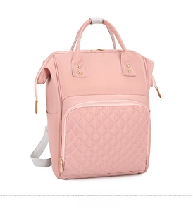 Pink nylon backpack detail with diamond quilted stitching and golden zippers