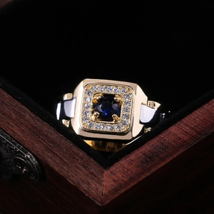 Luxury men's two-tone gold and silver ring with square blue gemstone in a wooden box