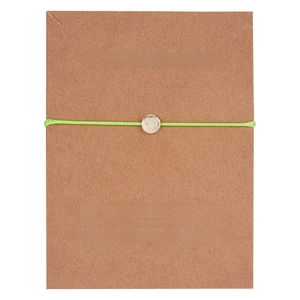 Detail of wish bracelet with neon green woven cord and gold circular charm on card