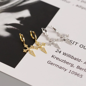 Macro detail of gold and silver S925 sterling silver cross earrings with zircon studs
