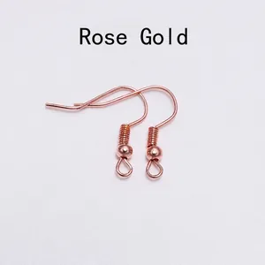 Detailed view of rose gold DIY earring hooks with bead and spring coil attachments