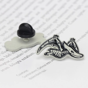Close-up of pterosaur skeleton brooch with black and white enamel detail and back clasp