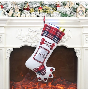 Detail of red and black plaid dog paw Christmas stocking with photo pocket on fireplace