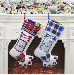 Close-up of dog paw Christmas stockings with photo slots on a festive fireplace
