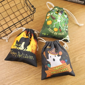 Halloween drawstring candy bags with black cat, skull and ghost designs on wooden background