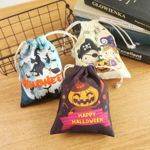 Halloween drawstring candy bags with pumpkin and witch cartoon patterns on wooden desk