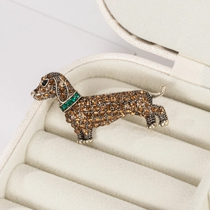 Vintage dachshund dog brooch with amber rhinestones on a white velvet jewelry gift box