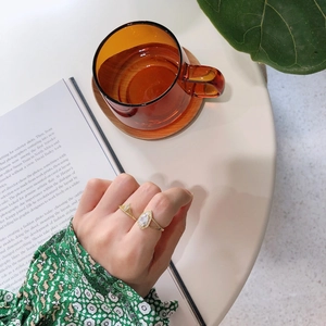 Close-up of a vintage golden geometric ring with zircons worn in a lifestyle setting