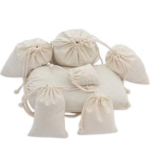 Vue détaillée de différentes tailles de sacs en coton beige à cordon de serrage