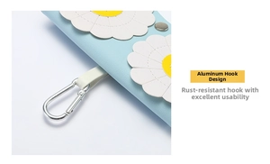 Détail d'un étui à lunettes en cuir bleu clair avec marguerites et mousqueton en aluminium