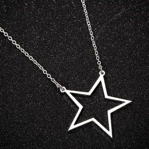 Polished silver stainless steel hollow star pendant necklace on a dark starry background