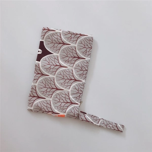 Detail of grey cotton bag with burgundy leaf pattern and convenient wrist strap