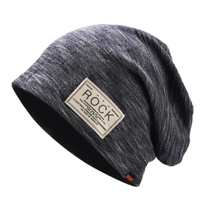 Close-up of heathered dark grey knit slouchy beanie featuring a Rock patch and orange label