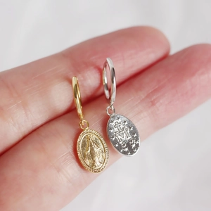 Detailed macro view of S925 sterling silver Virgin Mary coin earrings in gold and silver