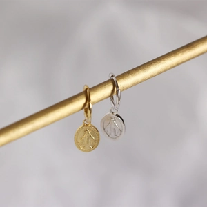 Close-up of gold and silver S925 sterling silver Virgin Mary coin drop earrings