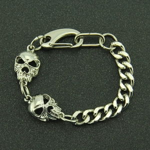Gros plan d'un bracelet tête de mort argenté avec chaîne cubaine et fermoir mousqueton