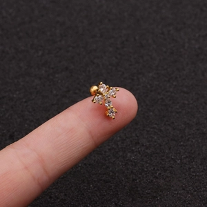 Vue détaillée d'une boucle d'oreille croix dorée avec zircons blancs et fermoir à vis