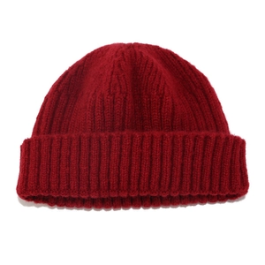 Macro shot of red knit beanie texture featuring thick ribbed weave and wide cuff detail