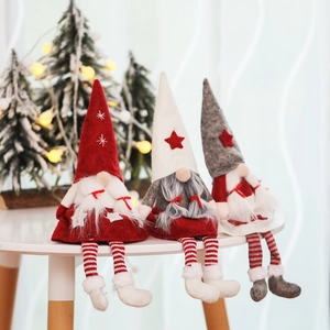 Trois gnomes de Noël aux longues jambes en rouge, blanc et gris assis sur le rebord