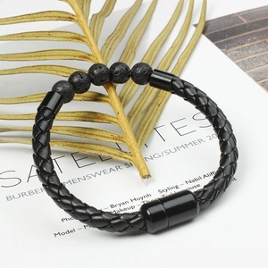Detail of black woven leather bracelet featuring natural lava beads and magnetic closure