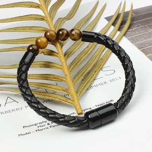Detail of men's braided leather bracelet with tiger eye beads and magnetic clasp