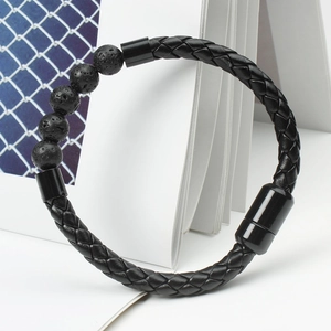 Detailed shot of men's black braided leather bracelet with natural lava stones and magnetic clasp