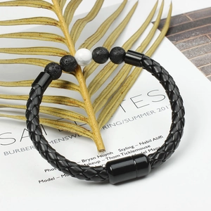 Detailed close-up of woven leather bracelet with black lava beads and a white marble bead