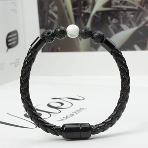 Macro shot of men's black braided leather bracelet with volcanic stones and magnetic clasp