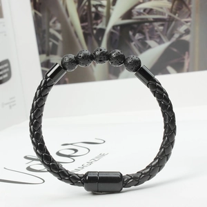Detail of men's black braided leather bracelet featuring natural volcanic stone beads