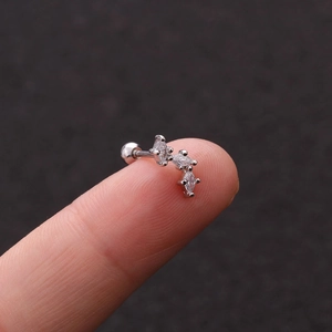 Macro shot of silver insect stud earring with three marquise-cut zircons on a fingertip